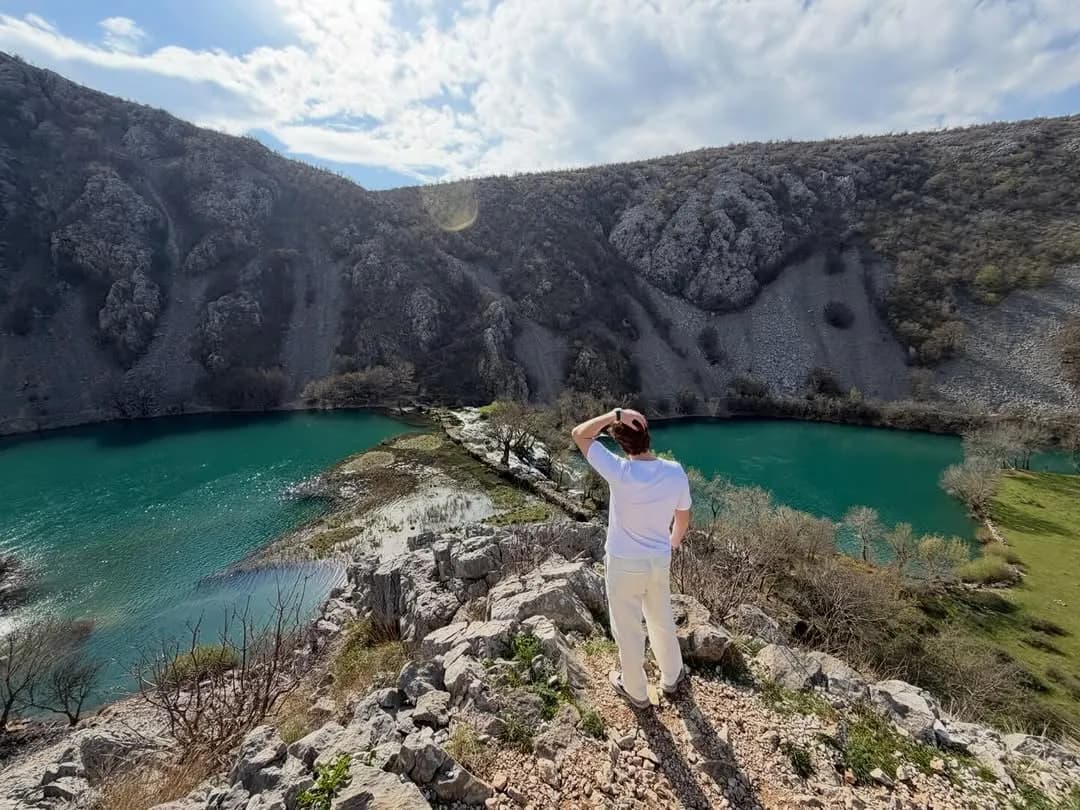 Andy on a rocky ridge above a turquoise river canyon in Croatia