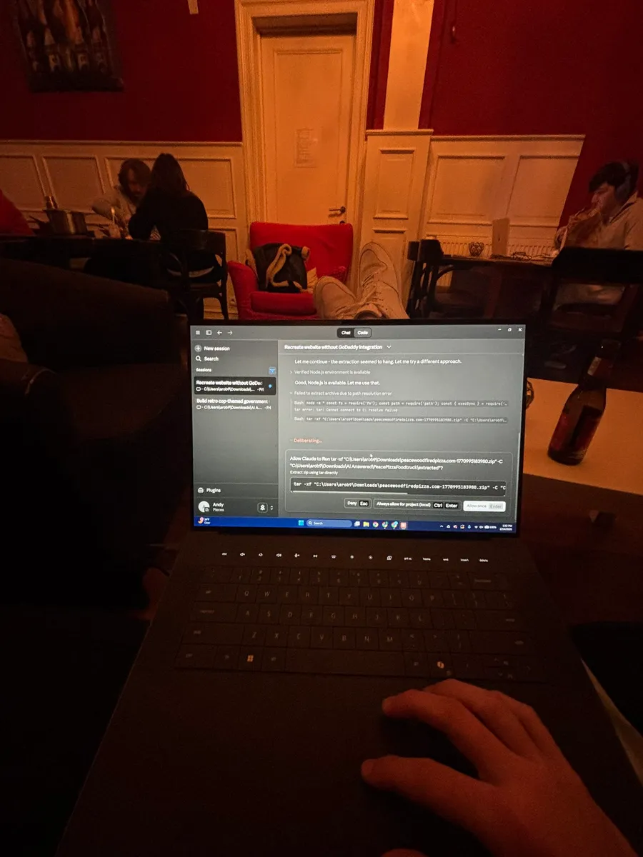 A laptop open in a warm red room in Bruges